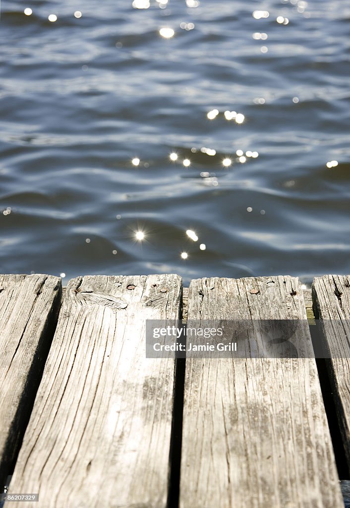 Close up of dock and sun reflecting on lake