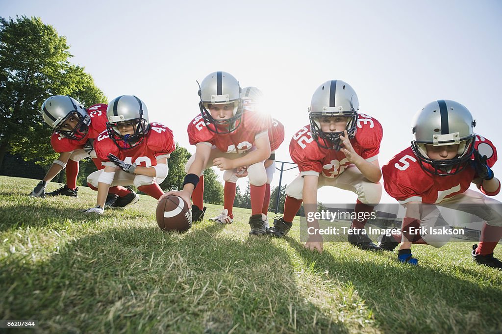 Football players at line of scrimmage ready to snap football