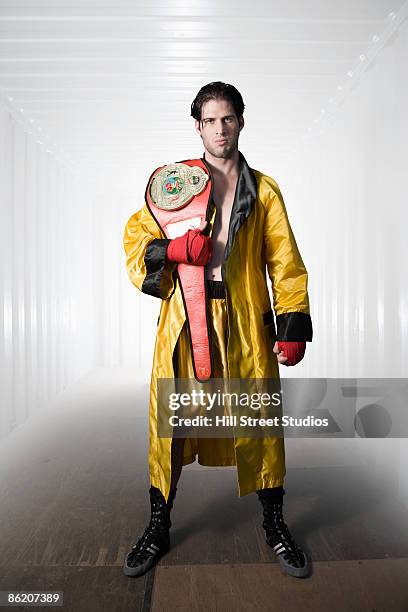 boxer in robe posing with championship belt - peignoir de boxe photos et images de collection