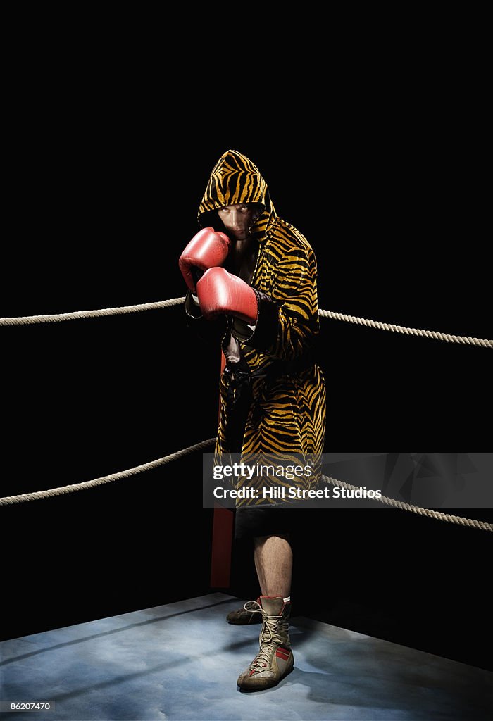 Boxer posing in fighting stance in boxing ring