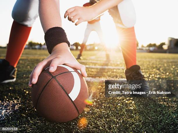 close up of football center preparing to snap football - quarterback stockfoto's en -beelden