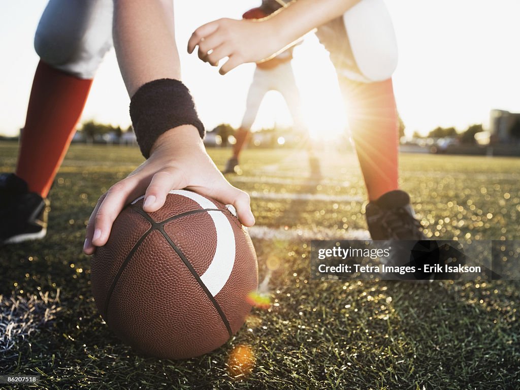 Close up of football center preparing to snap football