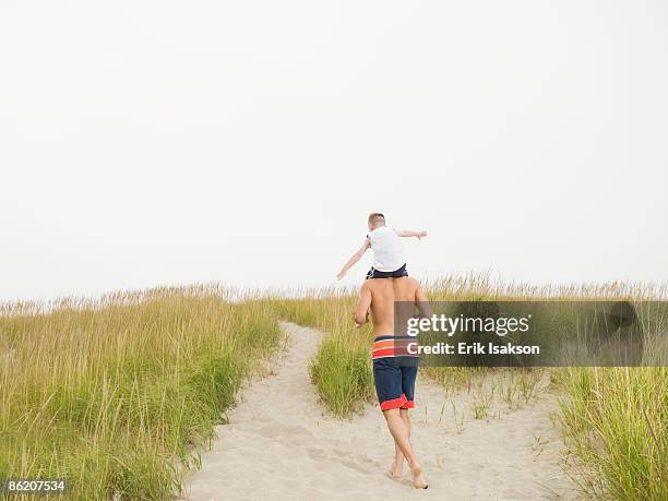 father carrying son on shoulders at beach - lincoln city oregon stock pictures, royalty-free photos & images