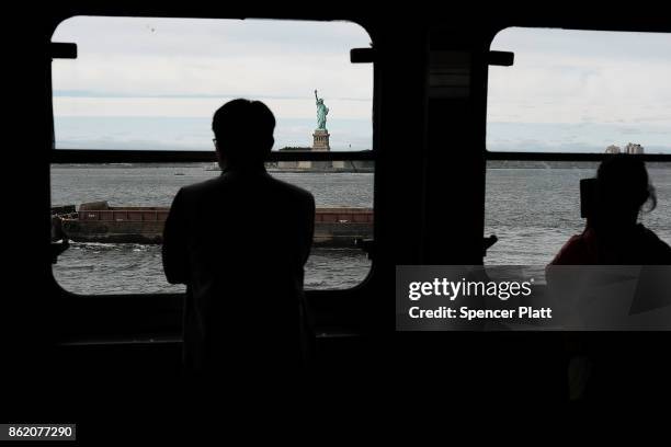 People look out at the Statue of Liberty from a ferry on October 16, 2017 in New York City. The U.S. Department of Justice has claimed that New York...