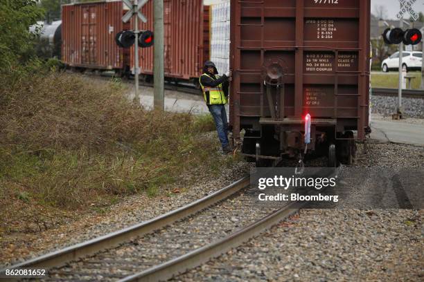 Worker stands on a CSX Corp. Freight train in Louisville, Kentucky, U.S., on Sunday, Oct. 15, 2017. CSX is scheduled to release earnings figures on...