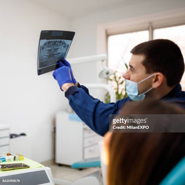 dentist showing x-ray to a patient - dental record stock pictures, royalty-free photos & images