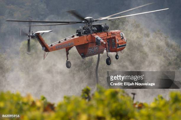 Tanker helicopter lifts off after refilling with water while fighting a wildfire on October 16, 2017 in Oakville, California. At least 40 people were...