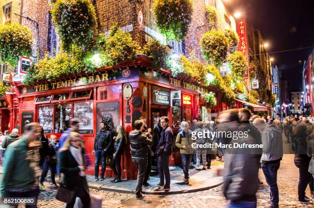 long exposure of temple bar in dublin with people drinking and walking by during night in autumn - dublin street imagens e fotografias de stock