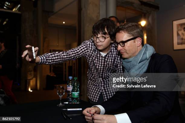 Director Nicolas Winding Refn poses with fans as he signs his book during 9th Film Festival Lumiere on October 16, 2017 in Lyon, France.