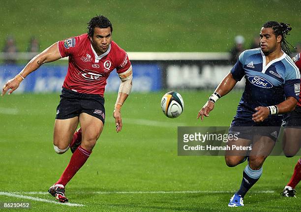 Digby Ioane of the Reds chips the ball past Taniela Moa of the Blues during the round 11 Super 14 match between the Blues and the Reds at North...