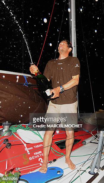 Frenck Erwan Tabarly, skipper of monohull "Athema" sprays champagne on April 25, 2009 upon his arrival at Grand-Bourg harbour on Marie-Galante island...