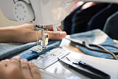 women's hand working on sewing machine