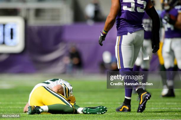 Aaron Rodgers of the Green Bay Packers lays on the field as Anthony Barr of the Minnesota Vikings walks away during the game on October 15, 2017 at...