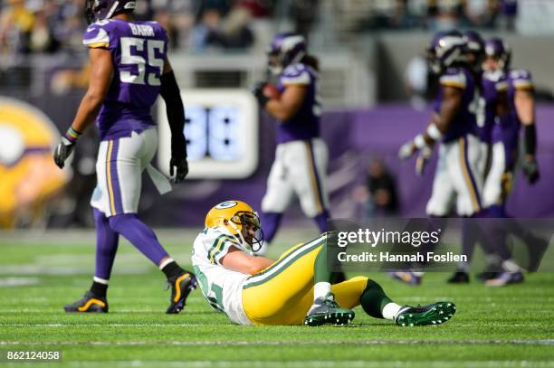 Aaron Rodgers of the Green Bay Packers lays on the field as Anthony Barr of the Minnesota Vikings walks away during the game on October 15, 2017 at...