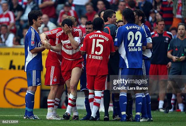 Mark van Bommel of Muenchen touches his face after a tackle with Jermaine Jones of Schalke during the Bundesliga match between FC Bayern Muenchen and...