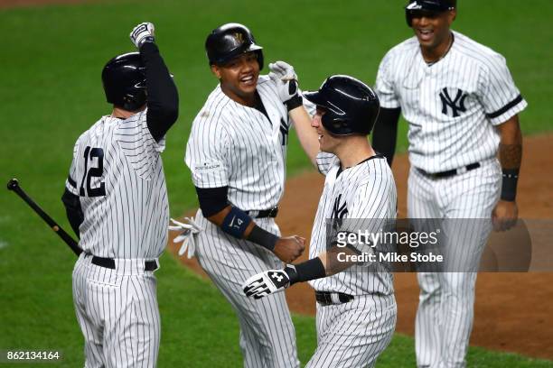 Todd Frazier of the New York Yankees celebrates hitting a 3-run home run with teammates Chase Headley and Starlin Castro against the Houston Astros...