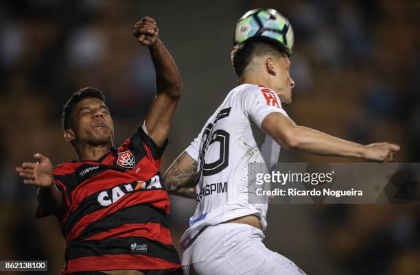 Lucas Crispim of Santos battles for the ball with Caique Sa of Vitoria during the match between Santos and Vitoria as a part of Campeonato Brasileiro...
