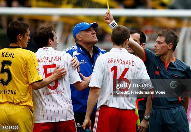 Referee Michael Kempter shows the yellow card to Joris Mathijsen of Hamburg after the Bundesliga match between Borussia Dortmund and Hamburger SV at...