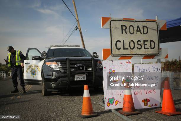 Handmade signs are seen attached to a road closure sign on October 16, 2017 in Oak Knoll, California. At least 40 people are confirmed dead, dozens...