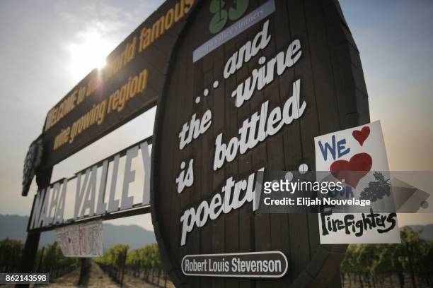 Handmade sign is seen attached to the Napa Valley welcome sign on October 16, 2017 in Oakville, California. At least 40 people are confirmed dead,...