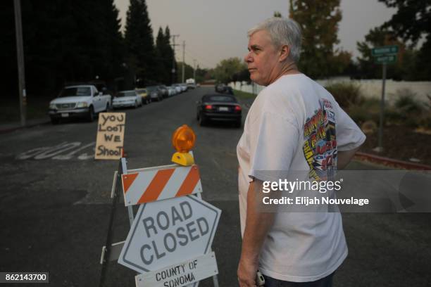 Ron Ekas stands at the front of his street to welcome returning residents after the mandatory evacuation order for Glen Ellen was lifted by...