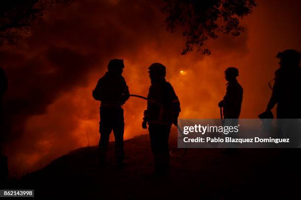 Firefighters work on a forest wildfire next to Vilarinho village, near Lousa on October 16, 2017 in Coimbra region, Portugal. At least 36 people have...