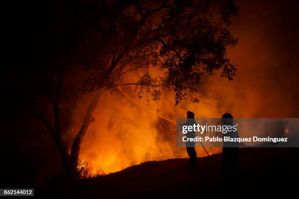 Firefighters battle a forest wildfire next to Vilarinho village, near Lousa on October 16, 2017 in Coimbra region, Portugal. At least 36 people have...