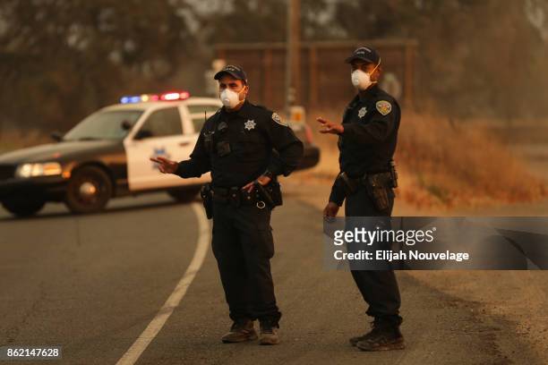 San Francisco police officers Malek Jisrawi and Sterling Hayes flag down a passing truck at a road closure checkpoint on October 16, 2017 in Glen...