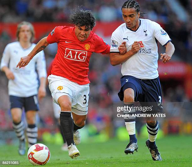 Manchester United's Argentinian forward Carlos Tévez vies with Tottenham Hotspur's Cameroonian defender Benoît Assou-Ekotto during the English...
