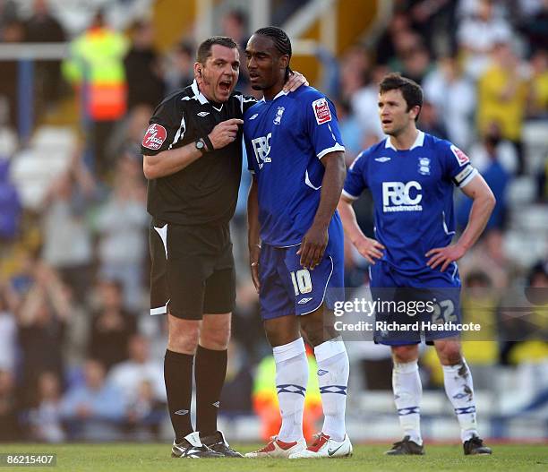 Referee Phil Dowd has words with Cameron Jerome of Birmingham after he tackled a fan who invaded the pitch during the Coca-Cola Championship match...