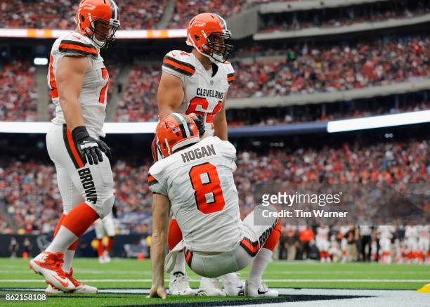 Chris Barker of the Cleveland Browns helps Kevin Hogan to his feet after being tackled in the end zone during the third quarter against the Houston...