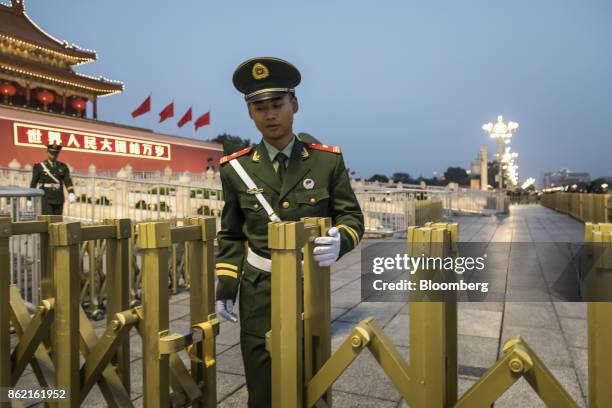 Member of the Chinese People's Liberation Army closes a gate at Tiananmen Square in Beijing, China on Monday, Oct 16, 2017. President Xi Jinping is...