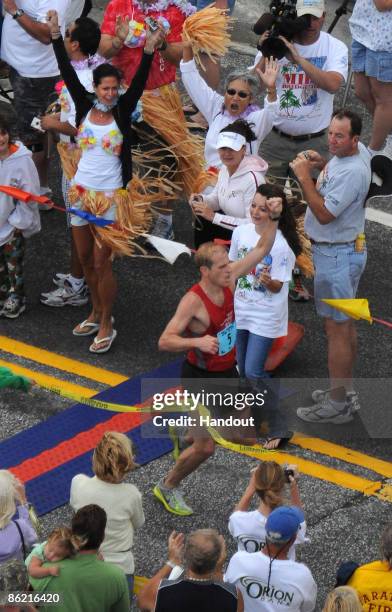 In this photo provided by the Florida Keys News Bureau, Jason Bodnar of Candler, North Carolina, crosses the finish line to win the men's overall...