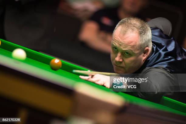 John Higgins of Scotland plays a shot during his first round match against Elliot Slessor of England on day one of 2017 Dafabet English Open at...