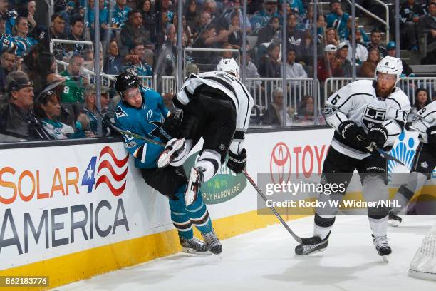 Christian Folin of the Los Angeles Kings hits Melker Karlsson of the San Jose Sharks at SAP Center on October 7, 2017 in San Jose, California.