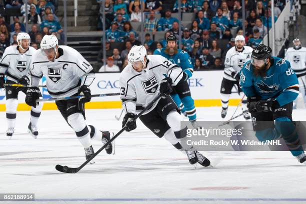 Dustin Brown of the Los Angeles Kings moves the puck as Anze Kopitar of the San Jose Sharks and Brent Burns of the San Jose Sharks skate at SAP...