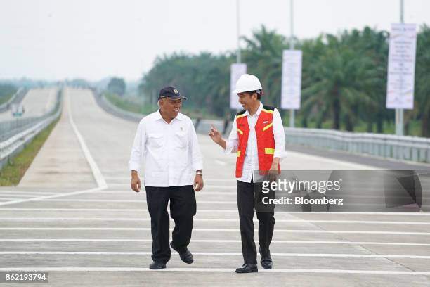 Joko Widodo, Indonesia's president, right, speaks with Basuki Hadimuljono, Indonesia's minister of public works and housing, during the inauguration...