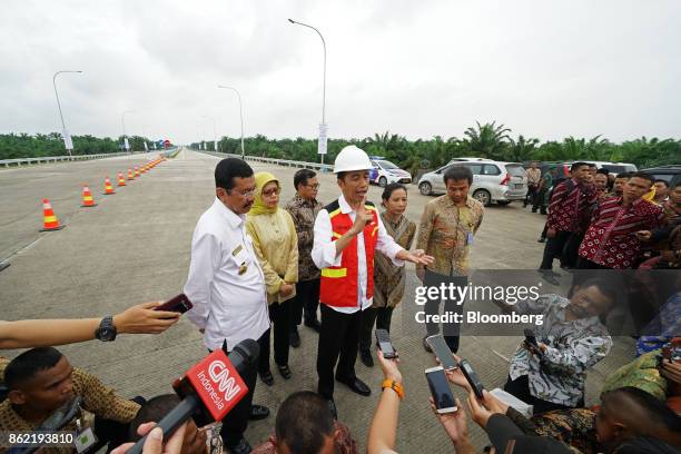 Joko Widodo, Indonesia's president, center, speaks to members of the media during the inauguration of the Medan-Kualanamu-Tebing Tinggi toll road in...