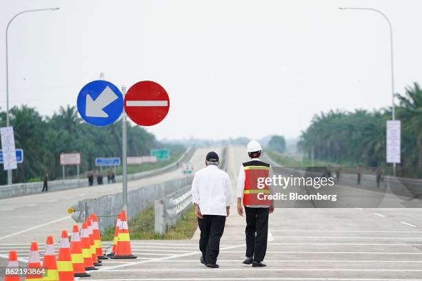 Joko Widodo, Indonesia's president, right, walks with Basuki Hadimuljono, Indonesia's minister of public works and housing, during the inauguration...