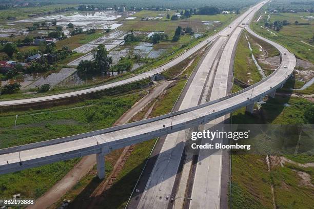 Section of the Medan-Kualanamu-Tebing Tinggi toll road is seen alongside farm land in this aerial photograph taken in Medan, North Sumatra,...