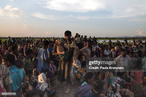 Man is carried after collapsing from dehydration as thousands of Rohingya refugees flee from Myanmar are kept under a tight security by Bangladeshi...