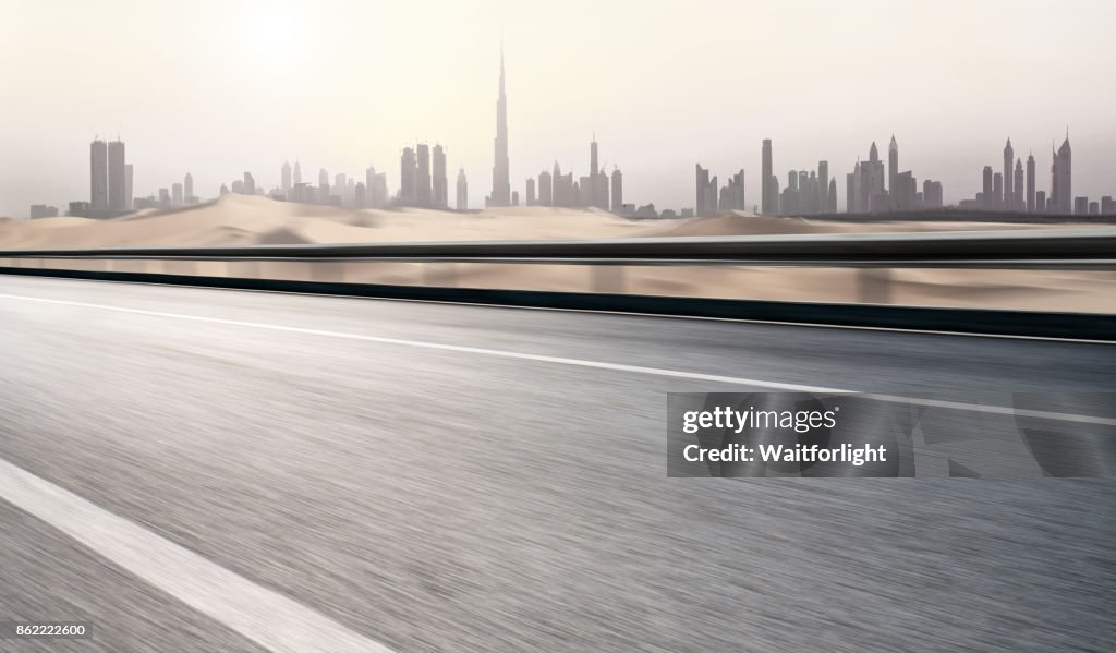 Empty road with dubai urban skyline