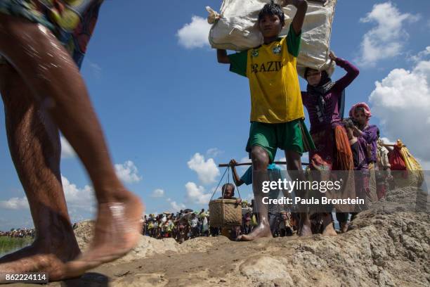 Thousands of Rohingya refugees fleeing from Myanmar walk along on a dirt path in a rice patty field in the hot sun near Palang Khali, Cox's Bazar,...