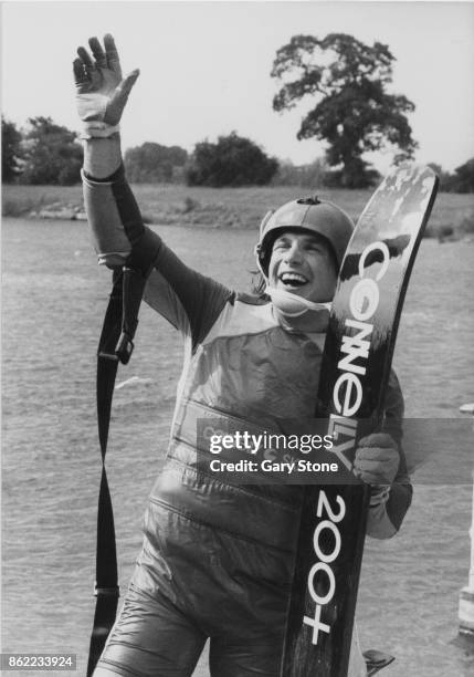 British water skiing champion Mike Hazelwood waves to the onlookers after his 187-foot jump at Thorpe Park, Middlesex, UK, 29th June 1980. The jump...