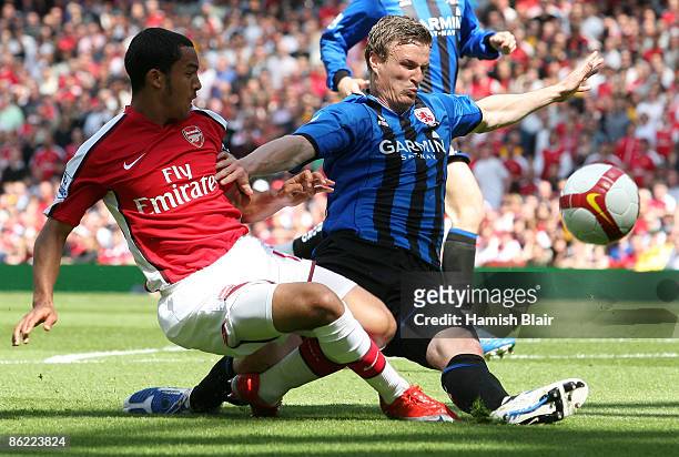 Theo Walcott of Arsenal battles for the ball with Robert Huth of Middlesbrough during the Barclays Premier League match between Arsenal and...