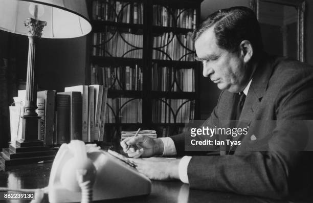 British Labour politician Denis Healey , the Secretary of State for Defence, working in the study of his flat in the Admiralty, London, during the...