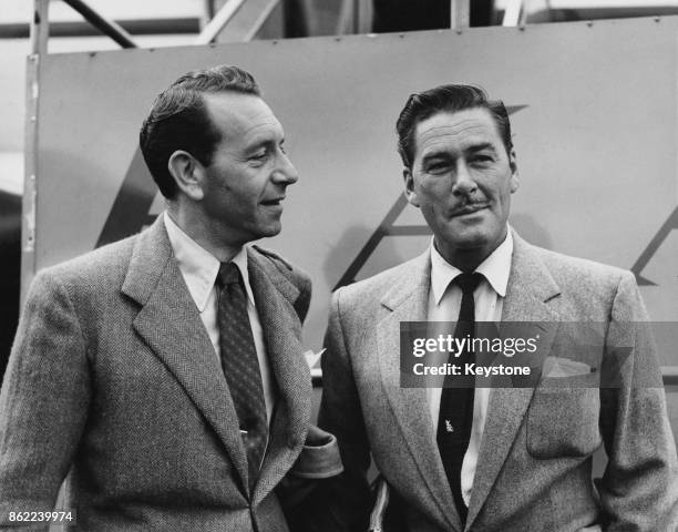 Austrian-born American actor Paul Henreid and Australian-born American actor Errol Flynn arrive in London Airport to begin work on their next films,...