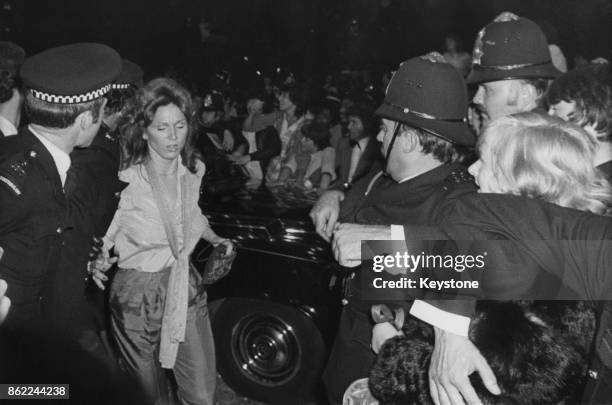 American actress Marilu Henner, the girlfriend of actor John Travolta, makes her way through fans outside the Empire Leicester Square at the UK...