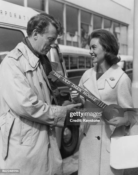 Actress Janette Scott welcomes actor and comedian Tom Poston to London Airport, by presenting him with a key to 'The Old Dark House', 10th May 1962....