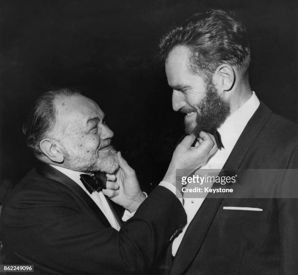 American actor Charlton Heston tugs the beard of fellow actor Edward G. Robinson at the annual awards dinner of the Directors' Guild at the Beverly...